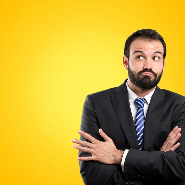 Hombre de negocios con los brazos cruzados sobre fondo amarillo —  Fotos de Stock