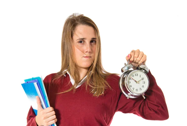 Student holding a clock over white background — Stock Photo, Image