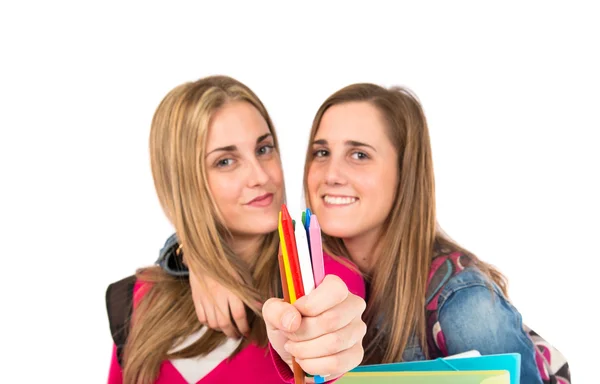 Estudantes segurando lápis de cor sobre fundo branco — Fotografia de Stock