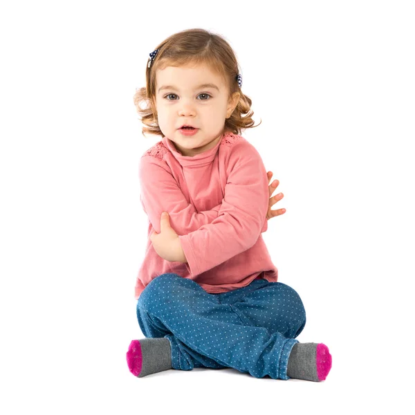 Malá holka sedí nad izolované bílé pozadí — Stock fotografie