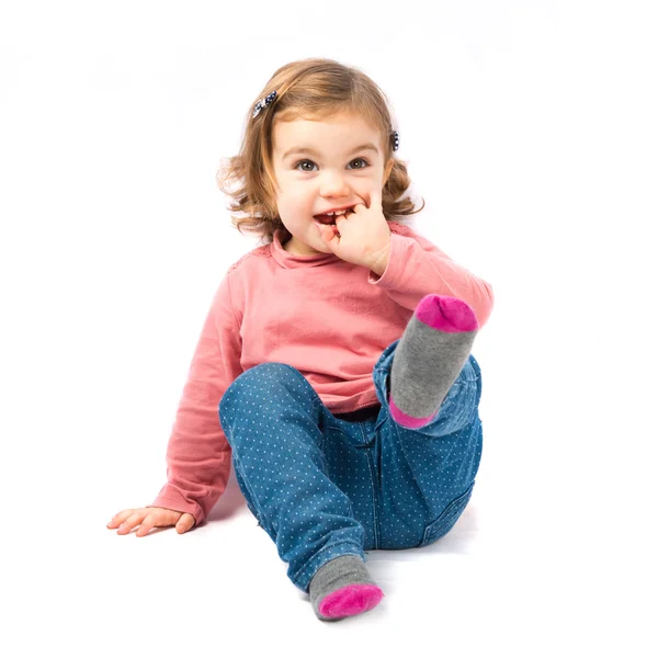 Leuk meisje zitten en lachen op witte achtergrond — Stockfoto