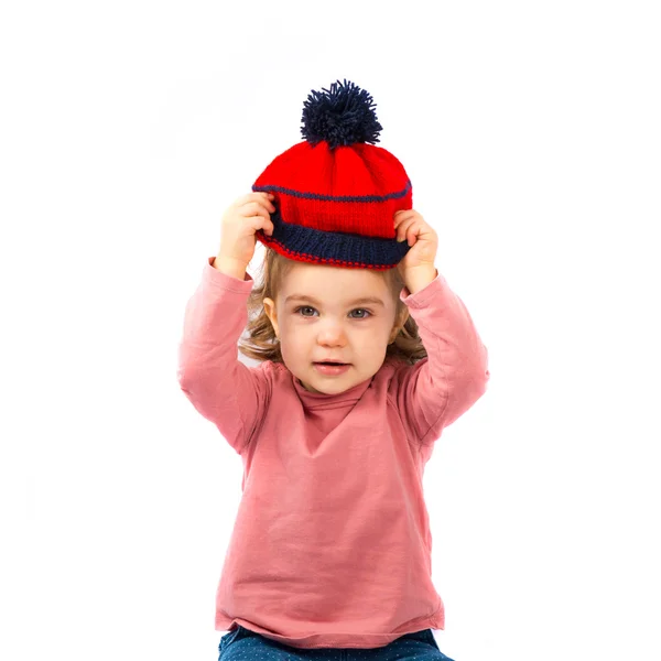 Kicsi lány, elhelyezés egy karácsonyi kalap alatt fehér háttér — Stock Fotó