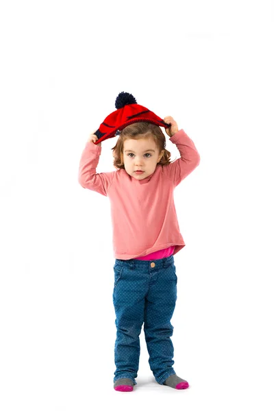 Niña poniéndose un sombrero de Navidad sobre fondo blanco — Foto de Stock