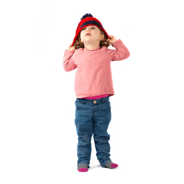 Bambina mettere su un cappello di Natale su sfondo bianco — Foto Stock