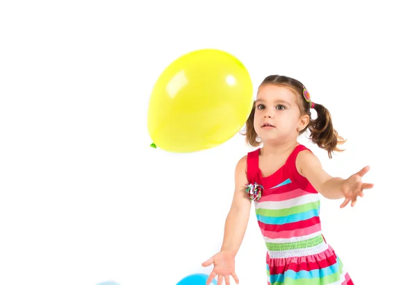 Kid playing with balloons over white background — Stock Photo, Image