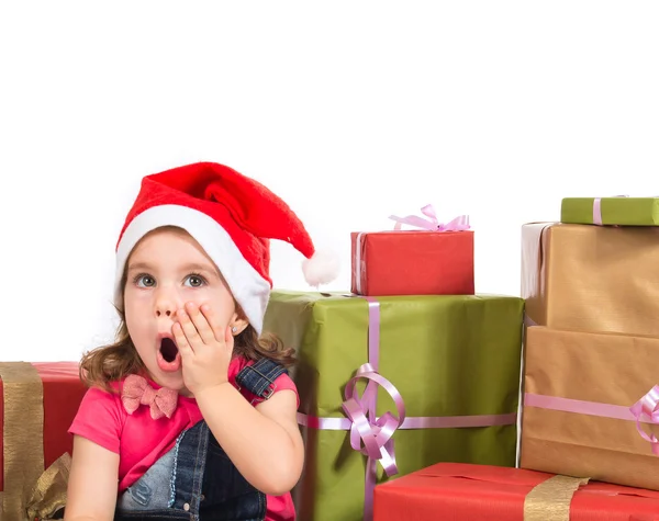 Blonde christmas kid around several presents doing surprise gest — Stock Photo, Image