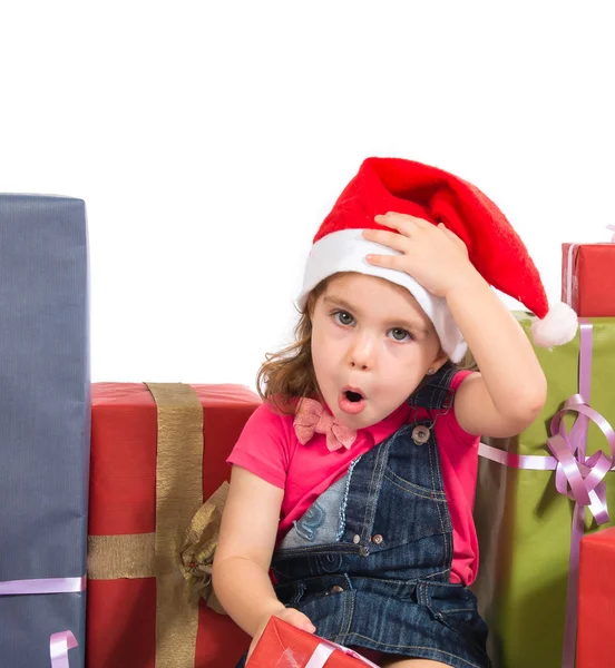 Blonde christmas kid around several presents doing surprise gest — Stock Photo, Image