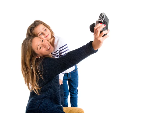 Mother and daughter photographing over white background — Stock Photo, Image