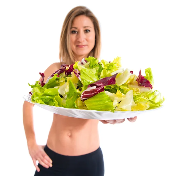 Donna sportiva che tiene un'insalata — Foto Stock