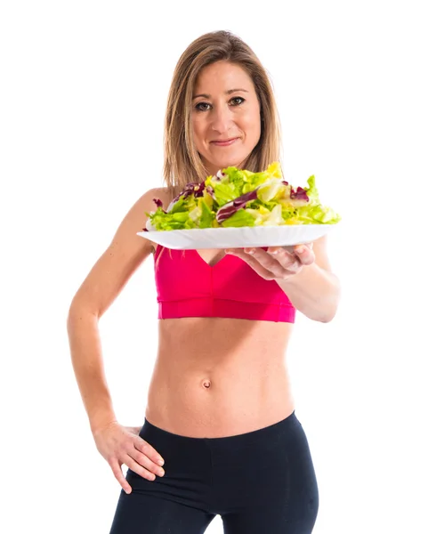 Donna sportiva che tiene un'insalata — Foto Stock