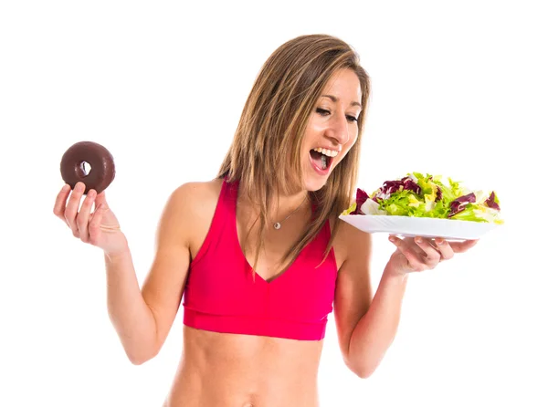 Жінка нерозрізнена між пончиком і салатом — стокове фото