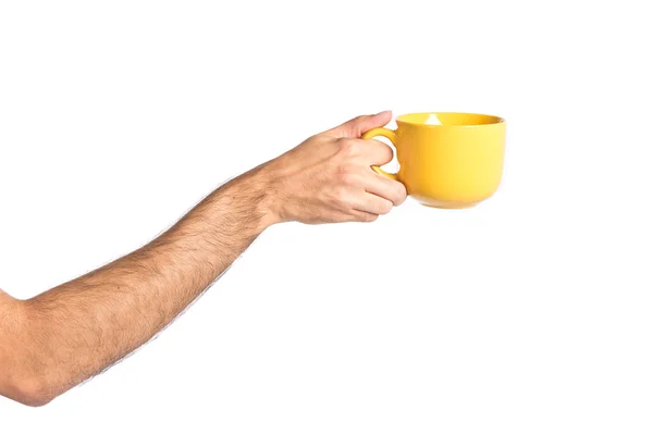 Hand hält eine gelbe Kaffeetasse über weiß — Stockfoto