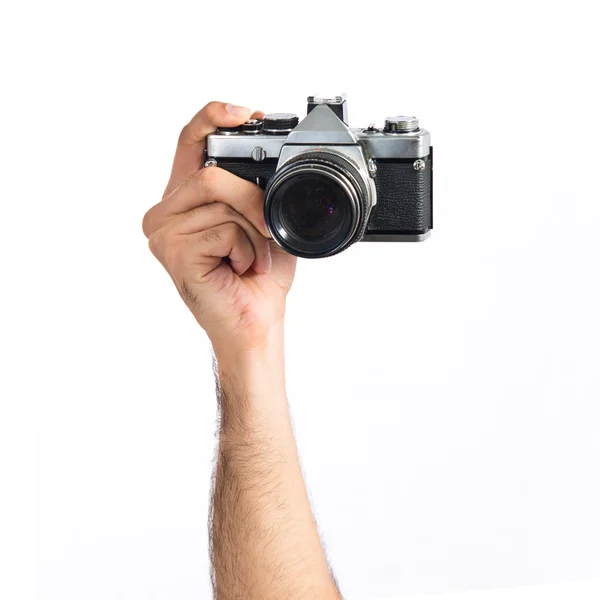 Mão segurando uma câmera sobre fundo branco — Fotografia de Stock