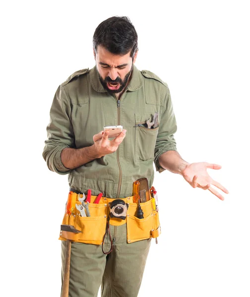 Angry mechanic talking to mobile — Stock Photo, Image