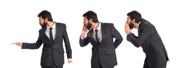 Businessman pointing and shouting over isolated white background — Stock Photo, Image