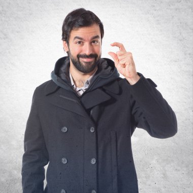 Beyaz arka plan üzerinde küçük işareti yapan erkek