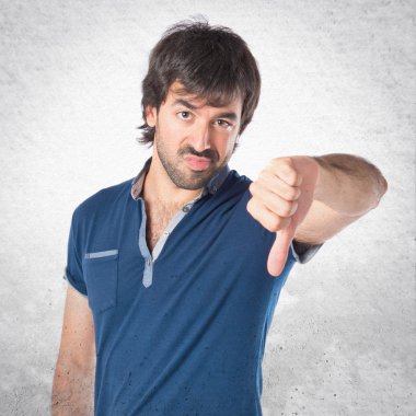 Beyaz arka plan üzerinde kötü bir sinyal yapan erkek