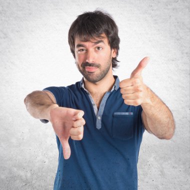 Beyaz arka plan üzerinde kötü bir sinyal yapan erkek