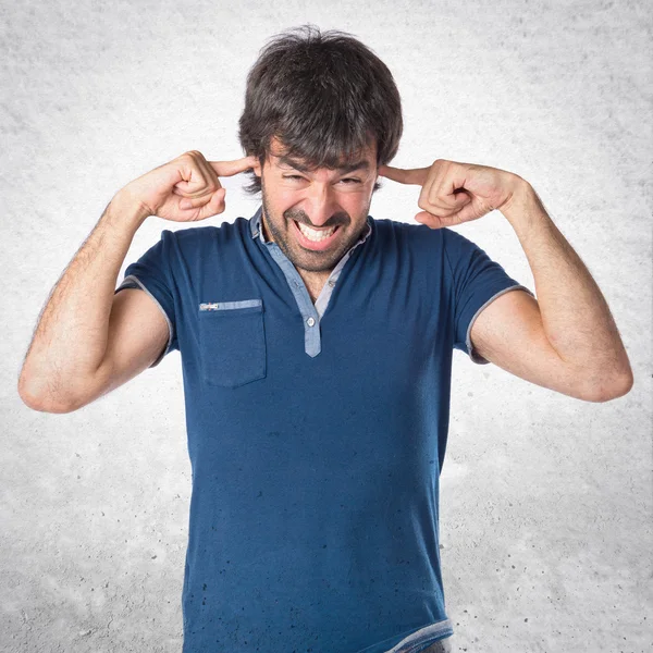 Mann verhüllt seine Ohren vor weißem Hintergrund — Stockfoto