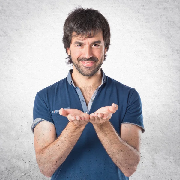 Man holding something over white background — Stock Photo, Image