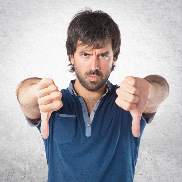 Hombre haciendo una mala señal sobre fondo blanco — Foto de Stock