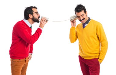 Bir teneke telefonu konuşurken ikiz kardeşler 