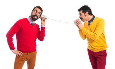 Bir teneke telefonu konuşurken ikiz kardeşler 