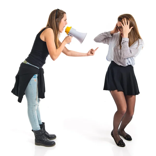 Girl shouting at her sister by megaphone — Stock Photo, Image