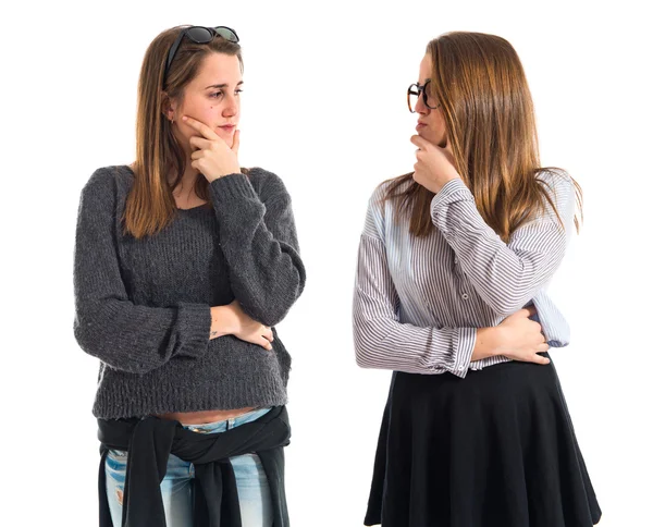 Hermanas gemelas pensando y mirándose — Foto de Stock