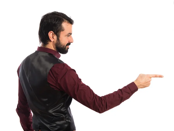 Man wearing waistcoat pointing to the lateral — Stock Photo, Image