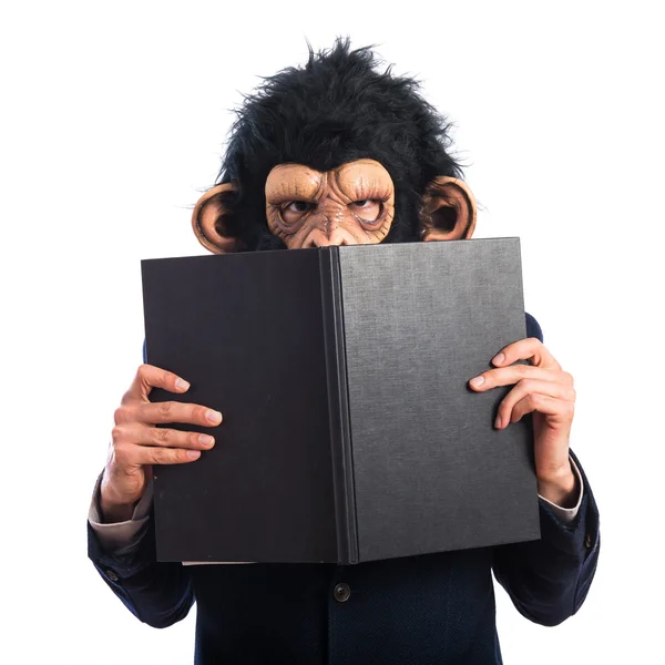 Ape man hiding behind a book — Stock Photo, Image