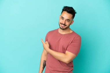 Kafkasyalı genç adam mavi arka planda izole edilmiş.