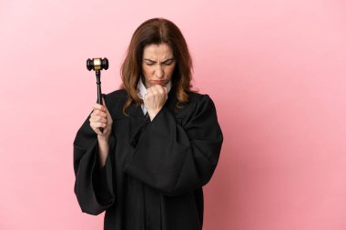 Pembe arka planda izole edilmiş orta yaşlı yargıç kadının şüpheleri var.
