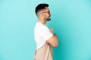 Restoran garsonu Kafkasyalı adam mavi arka planda yalıtılmış durumda.