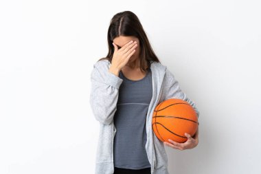 Basketbol oynayan genç bir kadın yorgun ve hasta bir ifadeyle beyaz arka planda izole edilmiş.