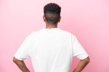 Genç Brezilyalı adam arka planda pembe arka planda izole edilmiş.