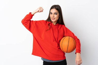 Beyaz arka planda izole edilmiş genç beyaz kadın basketbol oynuyor ve kendisiyle gurur duyuyor.