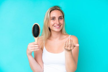 Saçları taranmış, mavi arka planda yaşayan beyaz genç bir kadın, bizimle gelmek için davet ediyor. Gelmene sevindim.