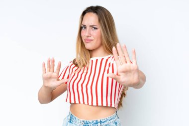 Beyaz arka planda izole edilmiş genç beyaz kadın ellerini öne uzatıyor.