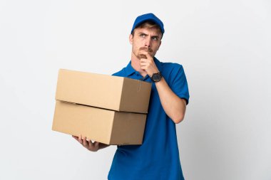 Young delivery blonde man isolated on white background having doubts and thinking