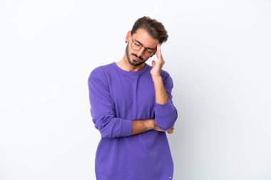 Beyaz arka planda başı ağrıyan genç beyaz bir adam.