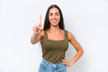 Beyaz arka planda izole edilmiş genç beyaz kadın parmağını kaldırıyor ve gösteriyor.