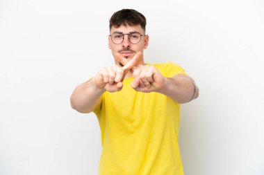 Beyaz arka planda izole edilmiş beyaz tenli yakışıklı bir adam bir eylemi durdurmak için eliyle jesti durduruyor.