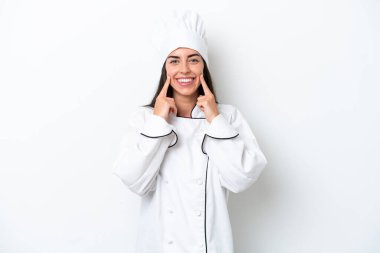 Beyaz arka planda, mutlu ve hoş bir ifadeyle gülümseyen genç aşçı kadın.