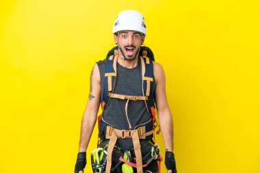 Kafkasyalı genç dağcı, sarı arka planda yalıtılmış, şaşırmış bir yüz ifadesi var.
