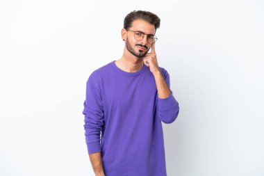 Beyaz arka planda izole edilmiş genç beyaz bir adam bir fikir düşünüyor.