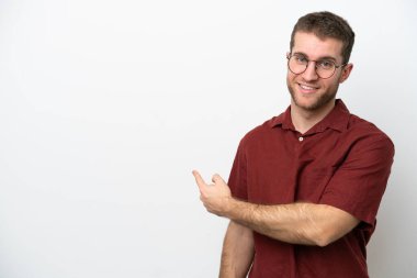 Beyaz arka planda izole genç beyaz adam geriye işaret ediyor