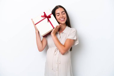 Beyaz arka planda izole edilmiş beyaz bir kadın hamile ve elinde bir hediye var.