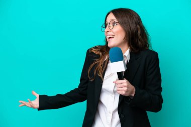 Genç TV sunucusu kadın, mavi arka planda, yana bakarken sürpriz bir ifadeyle izole edildi