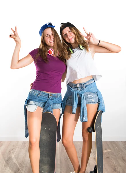 Dois amigos com seus skates fazendo gesto de vitória — Fotografia de Stock